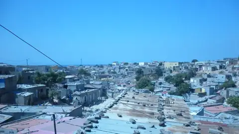 Imagem ilustrativa: Angola: Vista aérea de uma vila costeira com casas brancas e telhados azuis