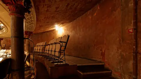 Imagem ilustrativa: Teatro abandonado com cadeiras e paredes desgastadas