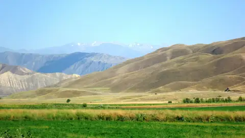 Imagem ilustrativa: Quirguistão: Paisagem montanhosa com campos verdes
